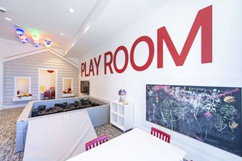 A play room with a large red letter M on the wall.