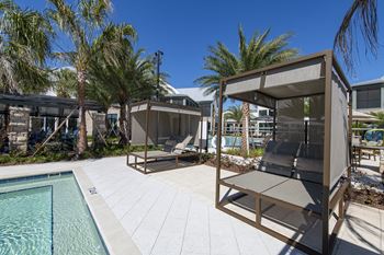 A poolside area with a sun lounger and a table.