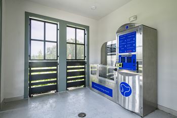 A vending machine sits in a room with a window.