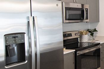 a kitchen with a stainless steel refrigerator and a stove