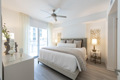 A bedroom with a large bed and a ceiling fan.