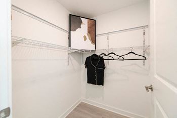 a walk in closet with a black shirt hanging on the wall