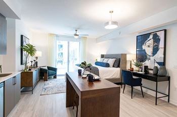 a bedroom with a bed and a desk and a living room