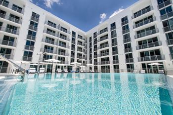 a large swimming pool in front of an apartment building