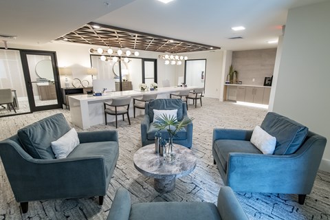 A modern living room with grey couches and a wooden ceiling.
