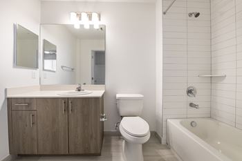 a bathroom with a toilet sink and tub and a mirror