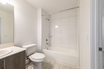a bathroom with a toilet and a tub and a sink