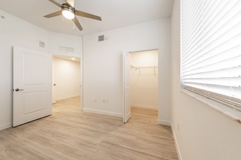 a living room with white walls and a ceiling fan