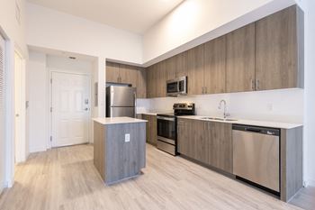 a renovated kitchen with stainless steel appliances and wooden cabinets