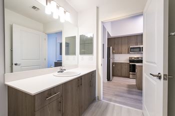 a white kitchen with wooden cabinets and a white sink