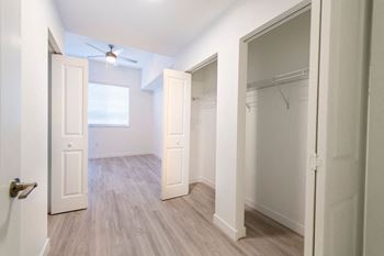an empty bedroom with a closet and a window