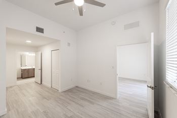 an empty living room with white walls and a ceiling fan