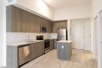 a renovated kitchen with stainless steel appliances and wooden cabinets