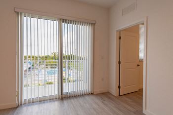 the living room of an apartment with a large window and a door