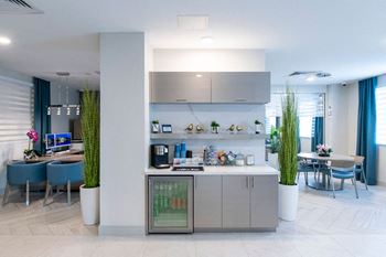 a modern kitchen and dining room with blue chairs and a table