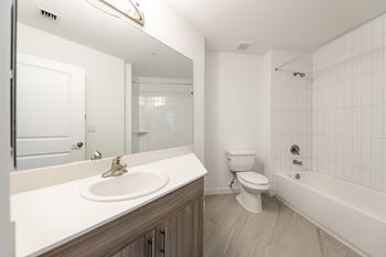 A white bathroom with a toilet, sink, and bathtub.