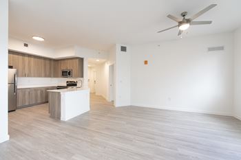 A spacious room with a ceiling fan and light fixture.