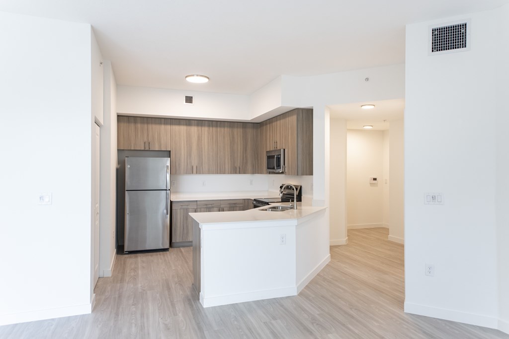 A kitchen with white countertops and a refrigerator.