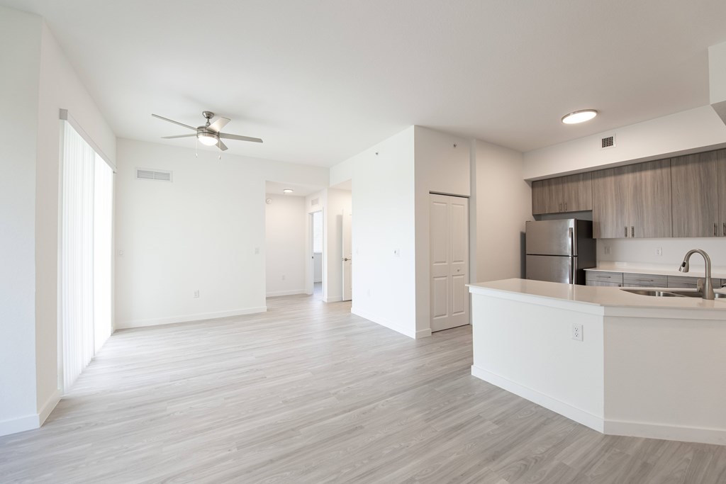 A spacious kitchen with a white countertop and a ceiling fan.