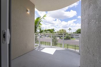 A view from a doorway looking out to a balcony with a metal railing.