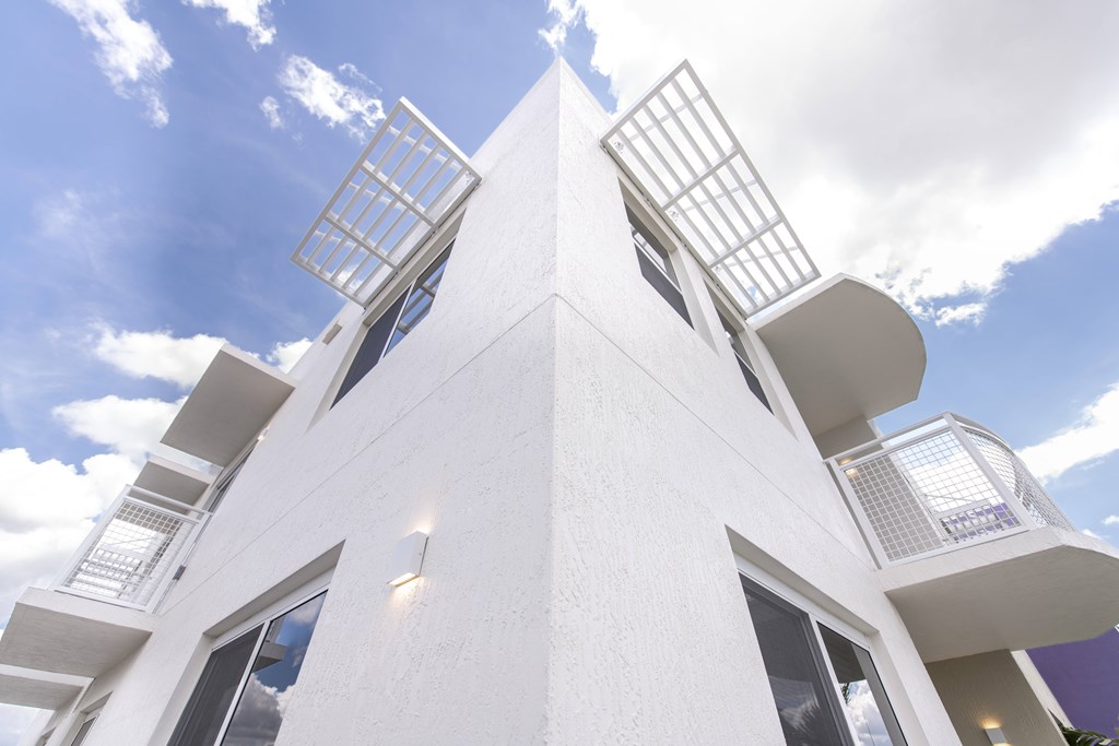 A white building with a unique design and a sky background.