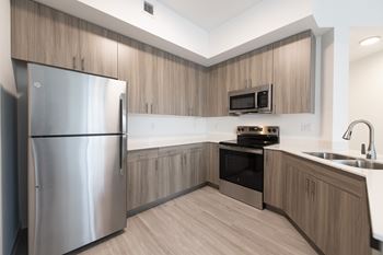 A modern kitchen with wooden cabinets and stainless steel appliances.