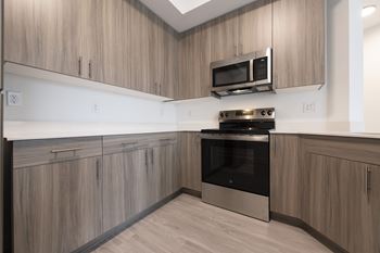 A modern kitchen with wooden cabinets and stainless steel appliances.