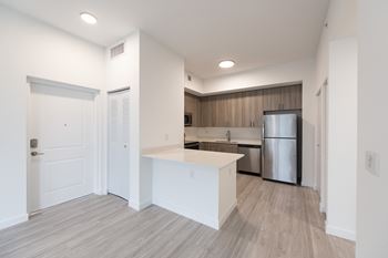 A kitchen with a white island and a stainless steel refrigerator.