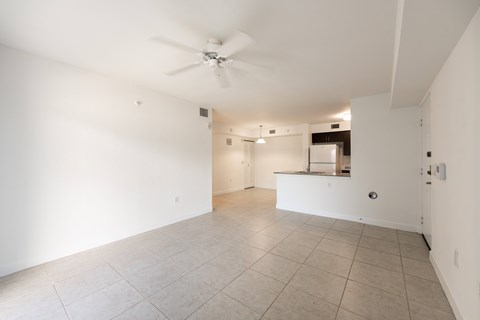 A spacious room with a ceiling fan and tiled floor.