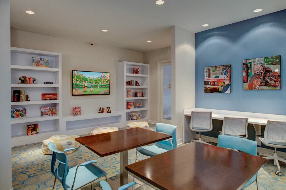 a conference room with tables and chairs and a bookshelf