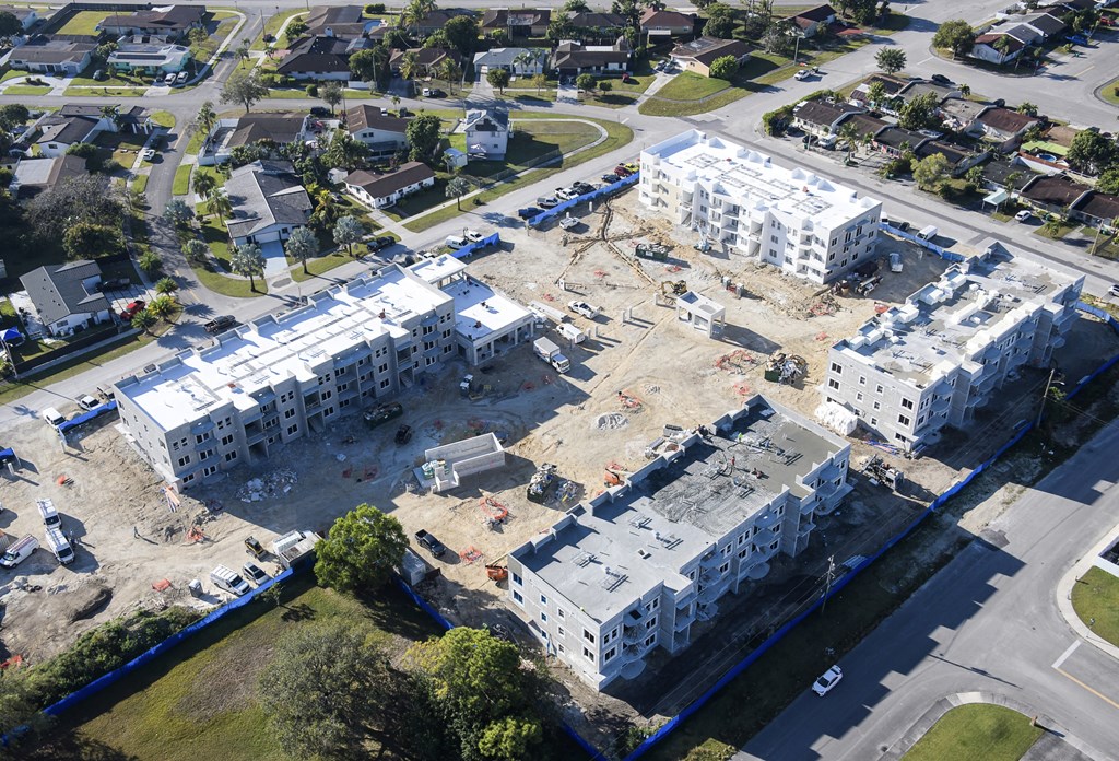 A construction site with a large building under construction surrounded by other buildings.