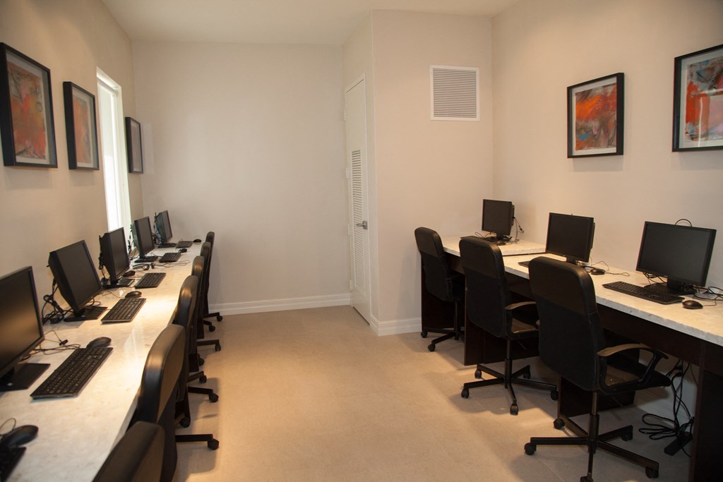 a room filled with desks with computers and chairs