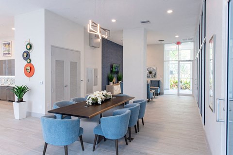 a long dining room with blue chairs and a long table