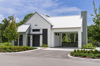 A modern building with a white exterior and a grey roof.