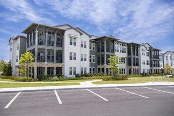 A large, modern building with a parking lot in front.