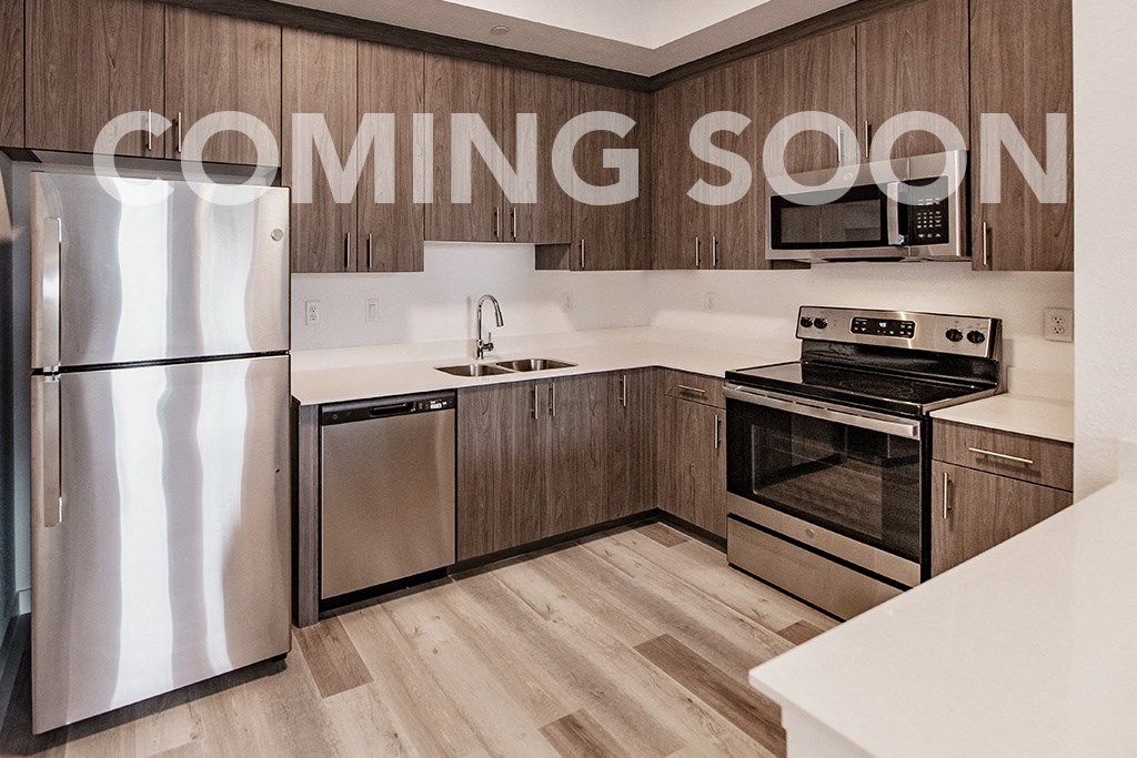 a kitchen with wooden cabinets and stainless steel appliances   coming soon on the wall