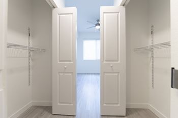 A white pantry with two doors and a fan.