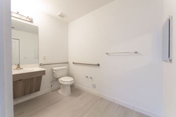 A white bathroom with a toilet, sink, and a towel bar.