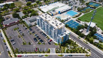 an aerial view of a city with a building and a parking lot