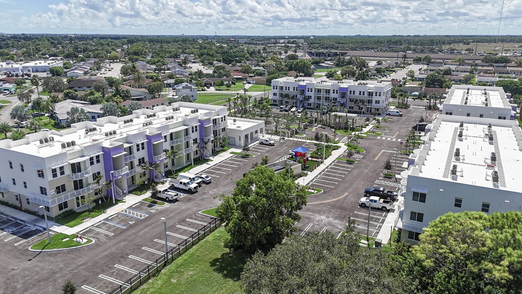 A parking lot is surrounded by apartment buildings.