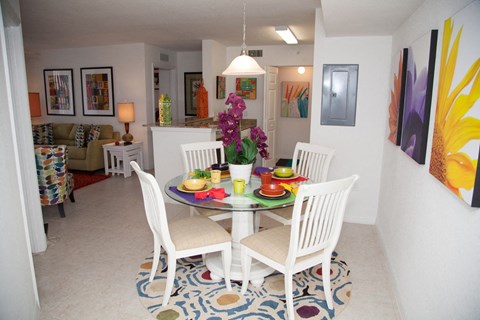 A dining room with a white table and chairs.