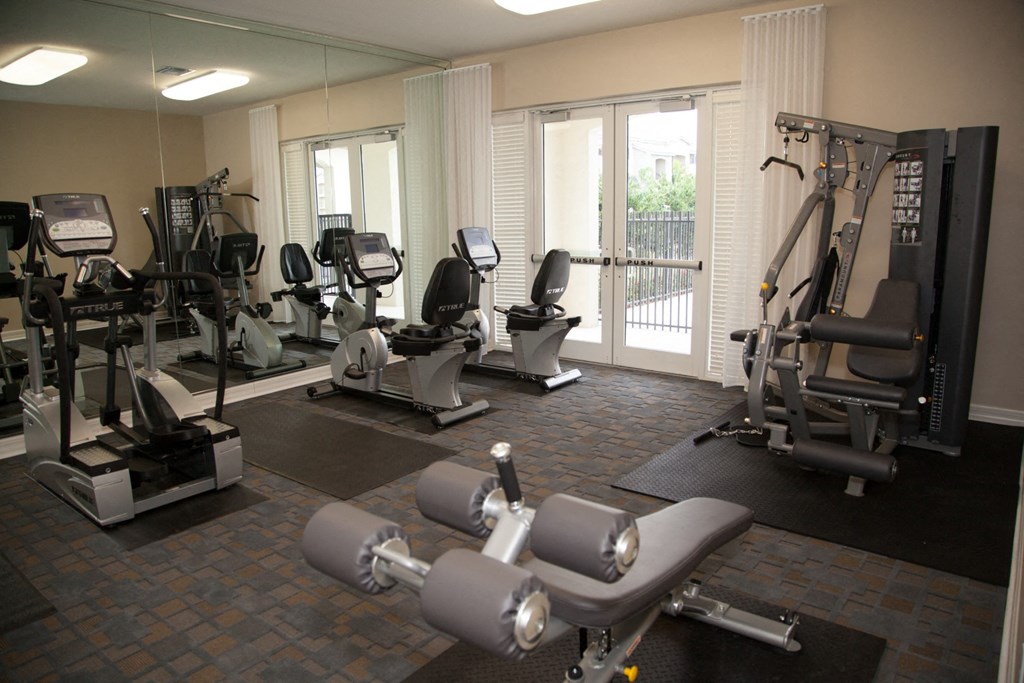 a gym with exercise equipment and windows in a building