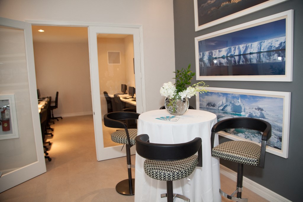 a dining room with a table and chairs and pictures on the wall