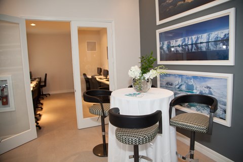 a dining room with a table and chairs and pictures on the wall