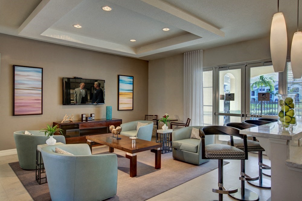 a living room with couches and chairs and a bar and a television