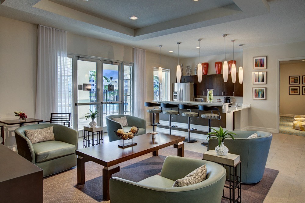 a living room with couches and chairs and a kitchen with a table and chairs