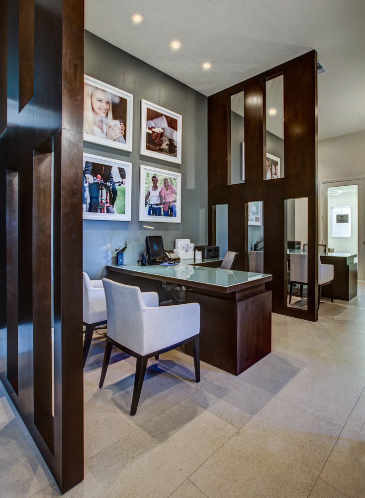 a modern office with a glass desk and chairs