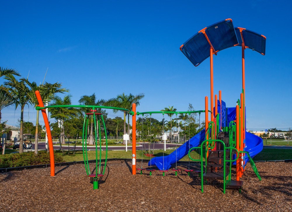 a playground with a swing set and slides in a park