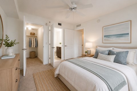 A bedroom with a large bed and a ceiling fan.