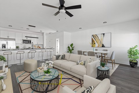 A modern living room with a glass coffee table and a white sofa.